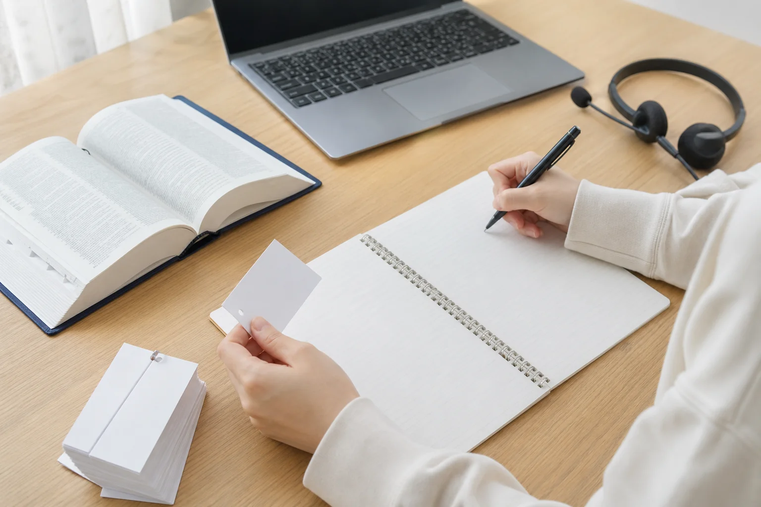 英語のノートに自動詞の一覧と例文を書き出している手元